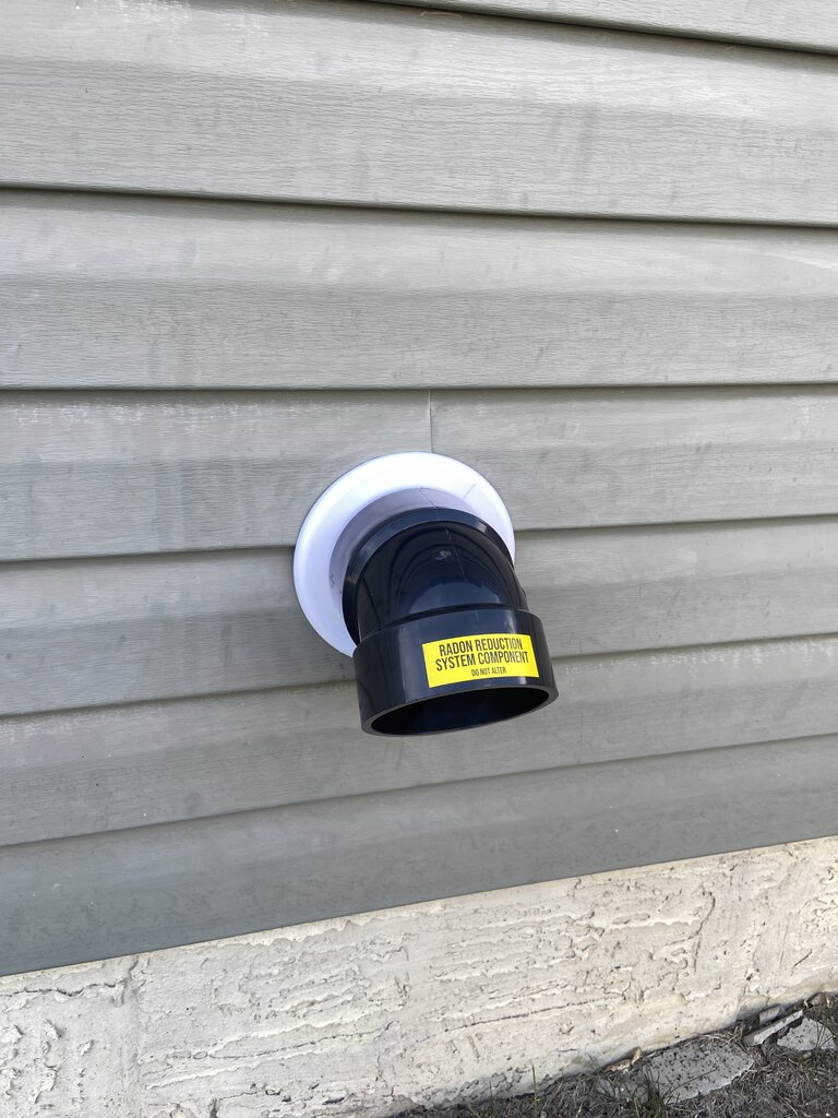 Radon mitigation system installed in Airdrie home basement — sub-slab depressurization pipe and fan by Bye Radon